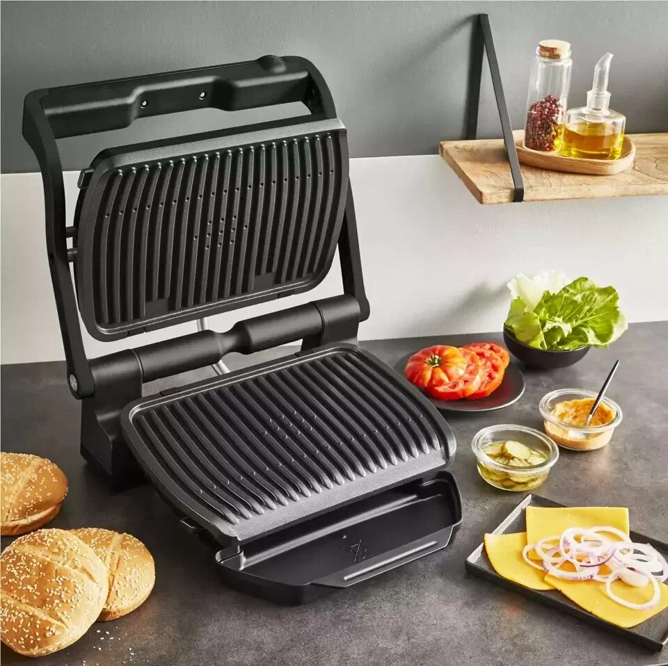 Tefal Optigrill+ GC717810 в открытом положении с бургерами, колбасками и овощами на рифлёных пластинах