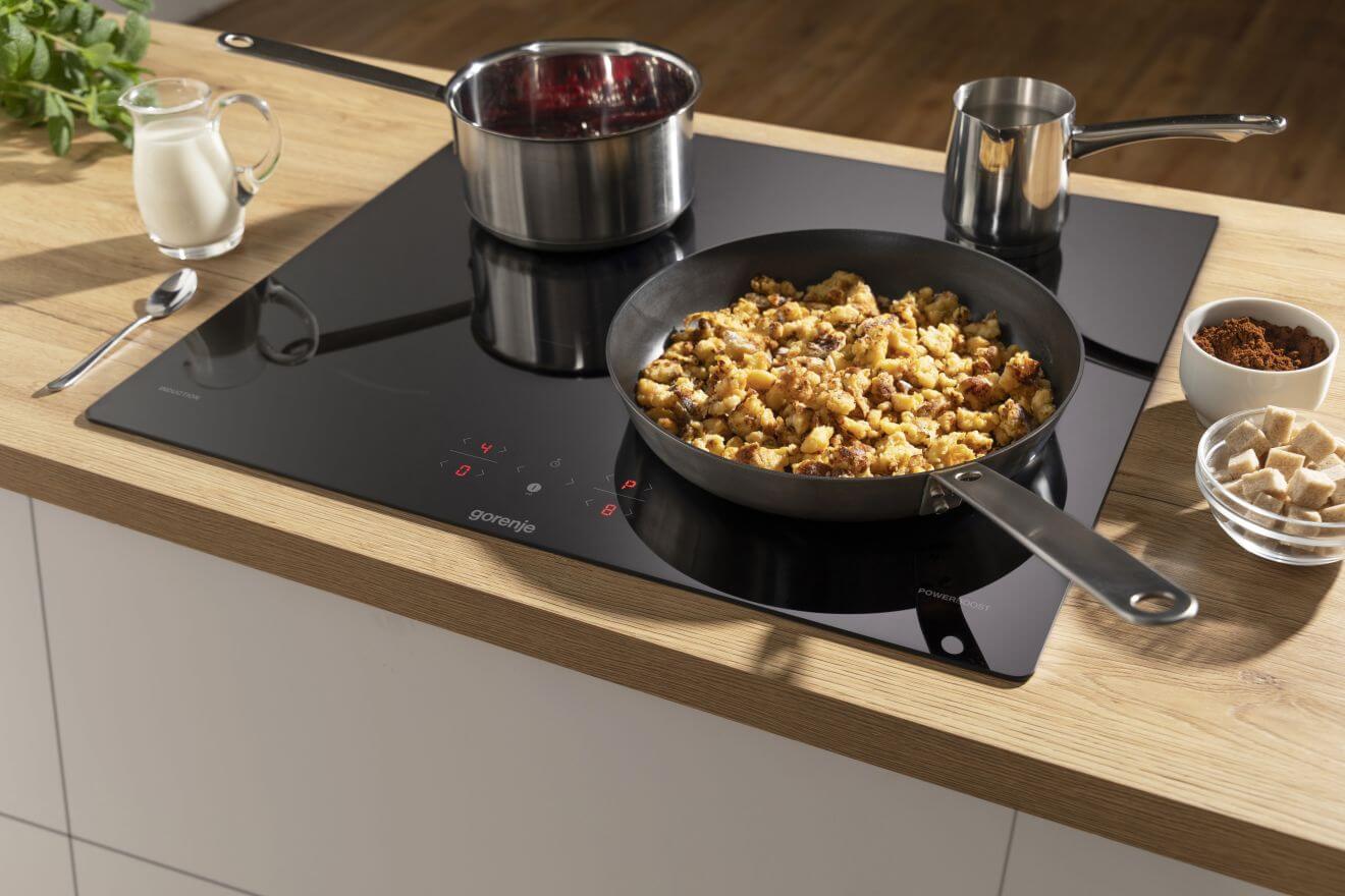 Gorenje GI6401BSCE вид сверху — все четыре индукционные зоны с посудой и продуктами
