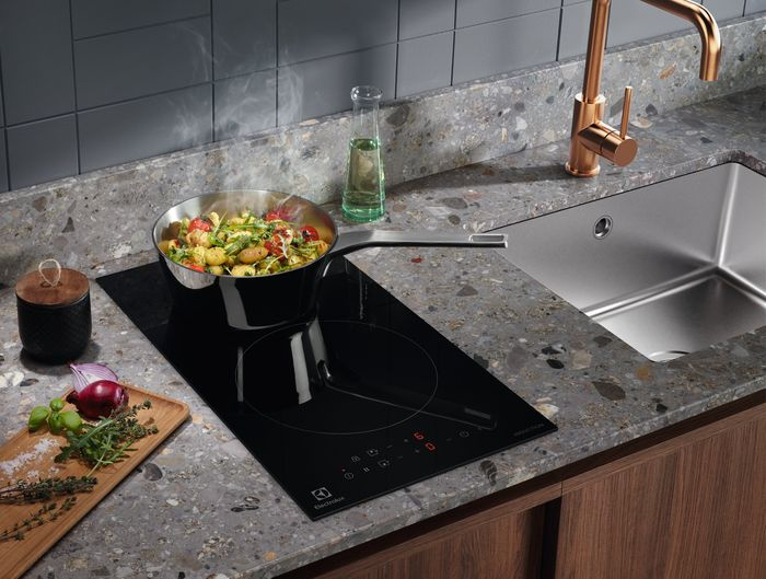 Electrolux LIT30231C встроена в столешницу — вид сверху с кастрюлей на конфорке